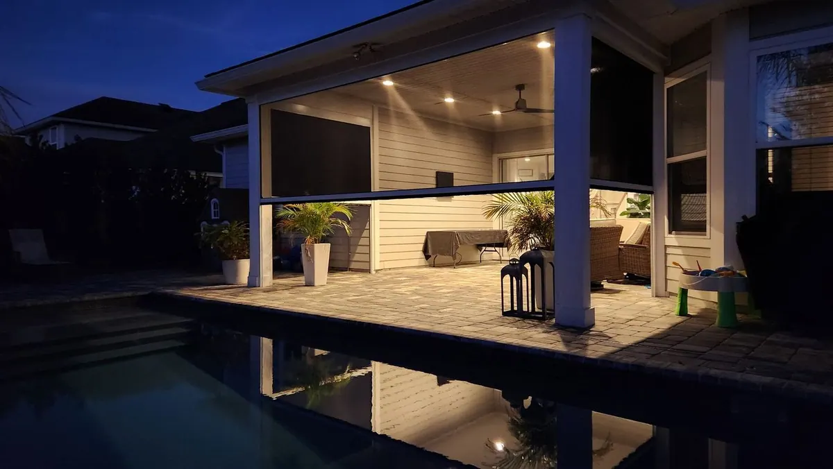 Motorized retractable patio screens lowered around an outdoor room